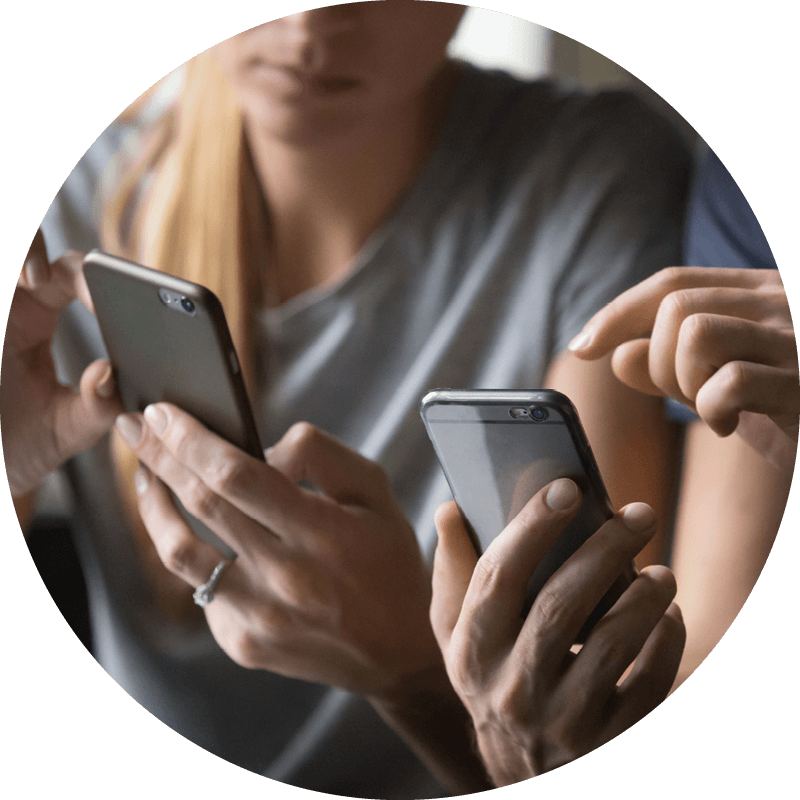 Two Eversense users holding smartphones, one points to the screen explaining data from CGM device